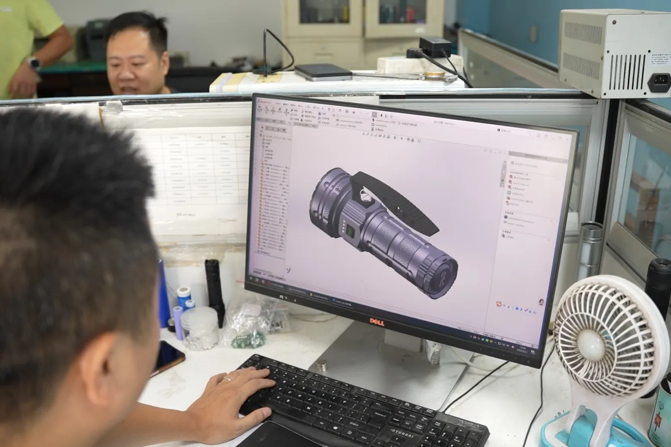 Engineer reviewing a flashlight CAD model for a private-mold program