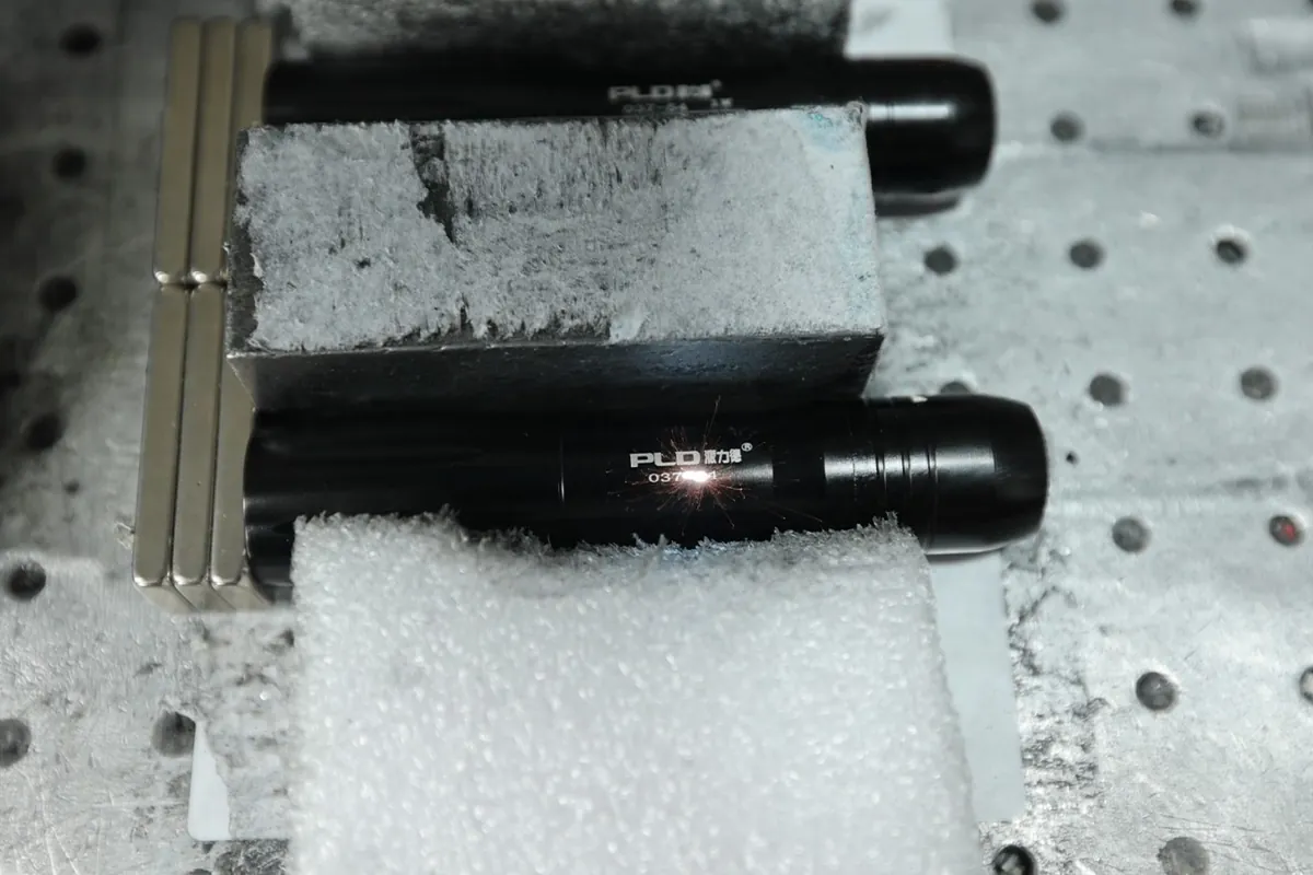 Laser marking a brand logo on an aluminum flashlight housing
